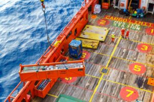 Aerial view of lifting activities on main deck supply vessel using platform crane. Lift up oil and gas materials and equipment.